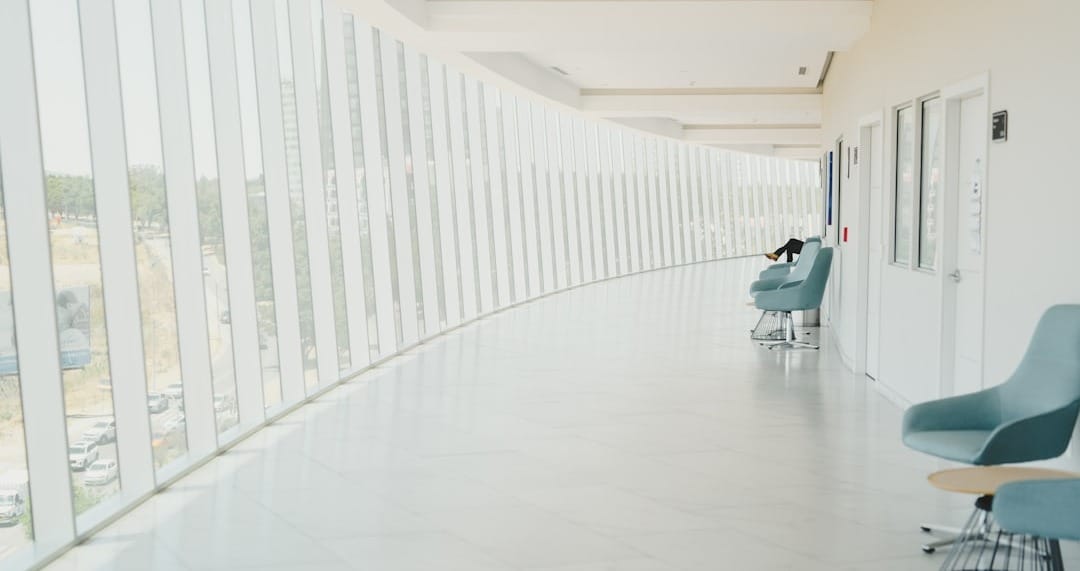 A long hallway with a row of chairs next to a wall